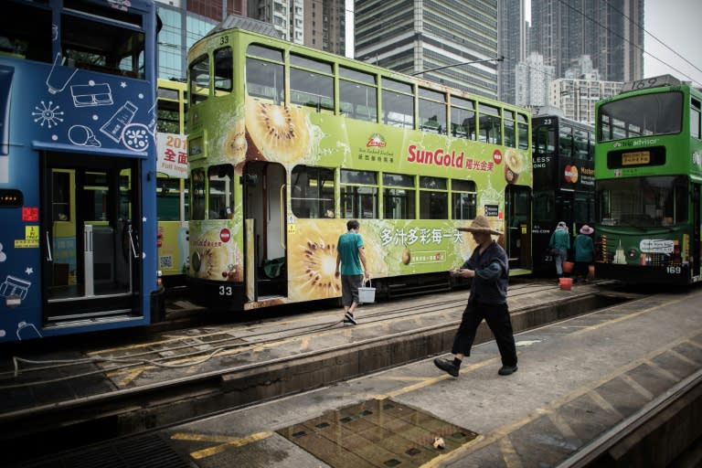 A worker walks by tramways parked at a tram depot in Hong Kong on August 25, 2015