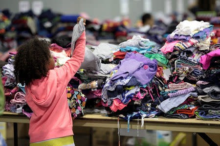 A child looks at donated clothes at a convention centre for Caribbean refugees whose homes were destroyed by Hurricane Irma, in San Juan, Puerto Rico September 14, 2017. REUTERS/Alvin Baez
