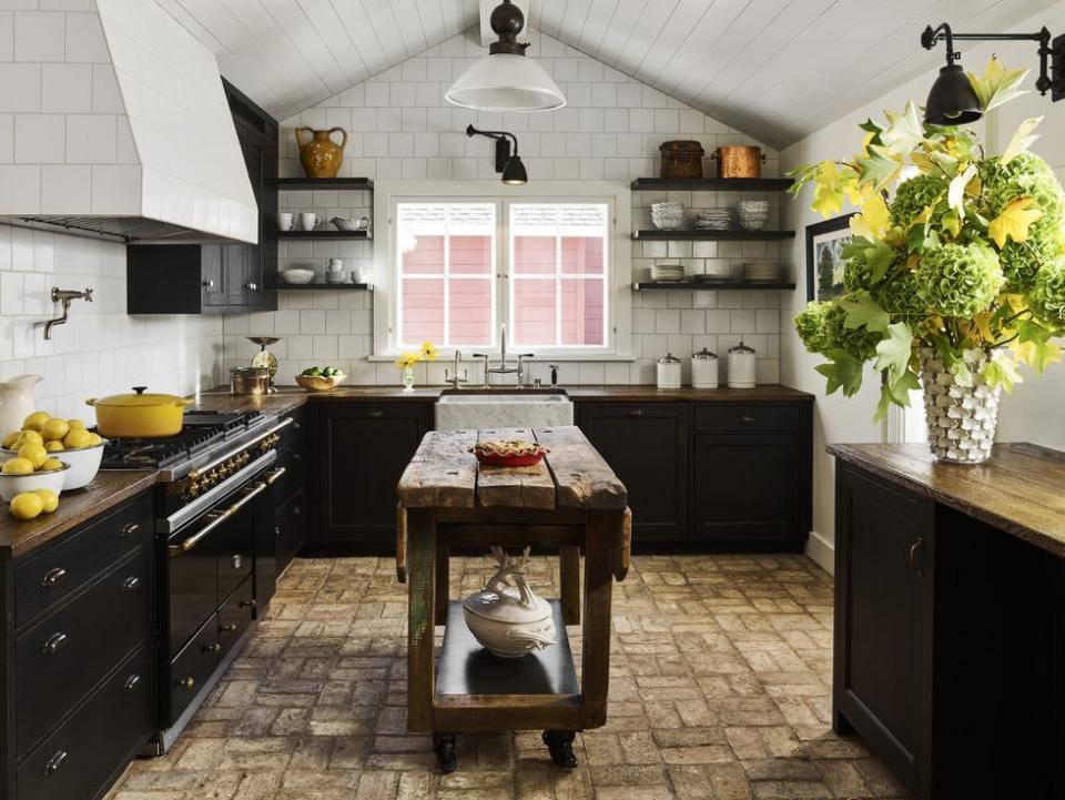 a kitchen with black cabinets and white tile walls