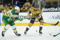 Minnesota Wild left wing Kevin Fiala (22) and Vegas Golden Knights defenseman Shea Theodore (27) vie for the puck during the first period of an NHL hockey game Wednesday, March 3, 2021, in Las Vegas. (AP Photo/John Locher)