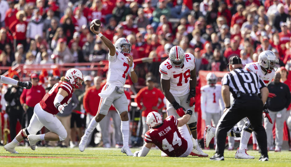 Ohio State quarterback C.J. Stroud (7) passes the ball while under pressure from Nebraska defensive lineman Casey Rogers, left, during the first half of an NCAA college football game Saturday, Nov. 6, 2021, at Memorial Stadium in Lincoln, Neb. (AP Photo/Rebecca S. Gratz)