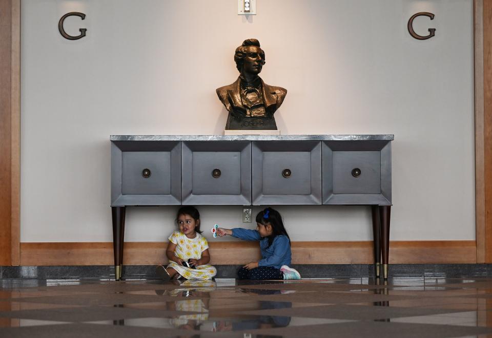 Two young girls play under a table during the Saturday afternoon session of the 193rd Semiannual General Conference of The Church of Jesus Christ of Latter-day Saints at the Conference Center in Salt Lake City on Saturday, Sept. 30, 2023. | Scott G Winterton, Deseret News