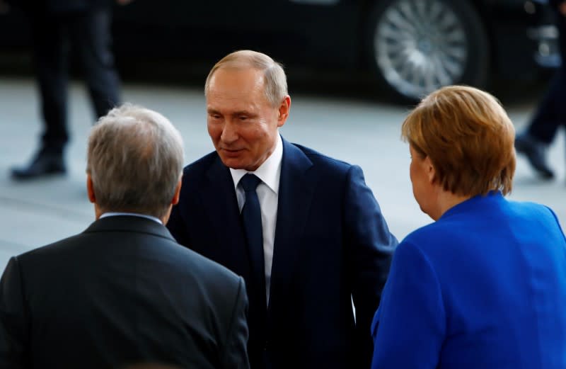 German Chancellor Angela Merkel and United Nations Secretary-General Antonio Guterres welcome Russian President Vladimir Putin at the Libya summit in Berlin