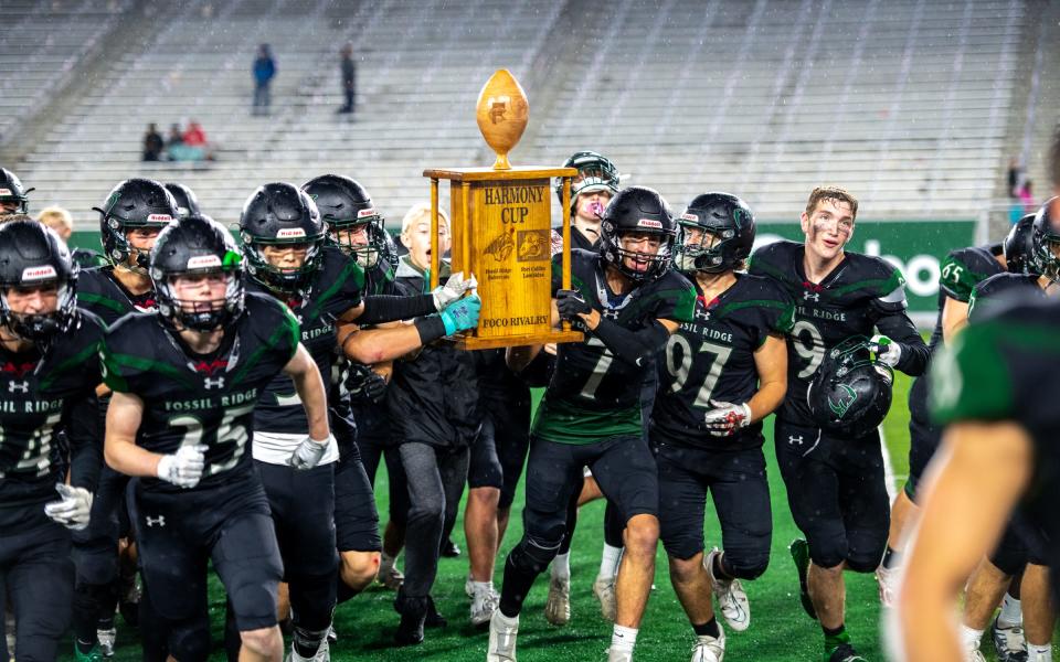 Fossil Ridge senior Ryan Pollyea (7) and his teammates rush to celebrate winning the Harmony Cup with the student section during the Canvas Community Classic at Canvas Stadium on Sept. 30, 2022. Fossil Ridge beat Fort Collins 46-21.