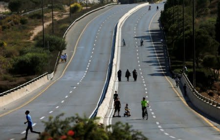 Children ride their bicycles in an empty street in Jerusalem during the Jewish holiday of Yom Kippur, September 19, 2018. Most Israeli Jews refrain from driving during the 25-hour period. REUTERS/Ammar Awad