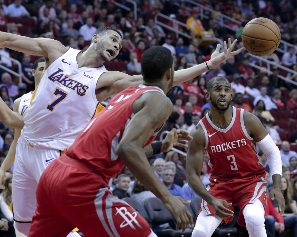 Los Angeles Lakers forward Larry Nance Jr. (7) reaches for a rebound between Houston Rockets forward Trevor Ariza (1) and guard Chris Paul (3) in the first half of an NBA basketball game, Wednesday, Dec. 20, 2017, in Houston. (AP Photo/Michael Wyke)