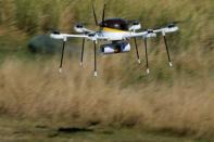 A drone, made by CyPhy Works, carries a UPS package on Children's Island off the coast of Beverly, Massachusetts during UPS's demonstration of a drone making a commercial delivery of a package to a remote or difficult-to-access location. REUTERS/Brian Snyder