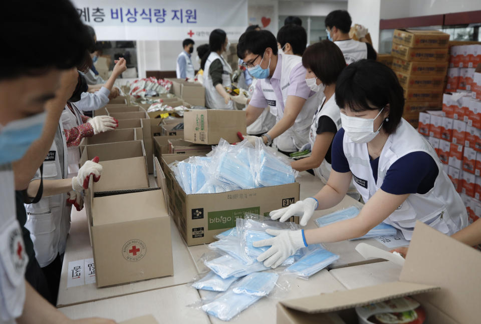 Red Cross workers prepare emergency relief kits packed with instant foods and masks for delivery to impoverished people at a facility of the Korean National Red Cross in Seoul, South Korea, Wednesday, June 3, 2020. (AP Photo/Lee Jin-man)