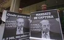 Protesters hold up posters with the image of former Banco Espirito Santo (BES) CEO Ricardo Salgado during a demonstration at BES's headquarters office in downtown Lisbon in this August 9, 2014 file photo. REUTERS/Hugo Correia/Files