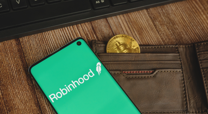 hood stock: An image of a wallet with a coin in it, a cellphone on top depicting Robinhood logo. Robinhood crypto