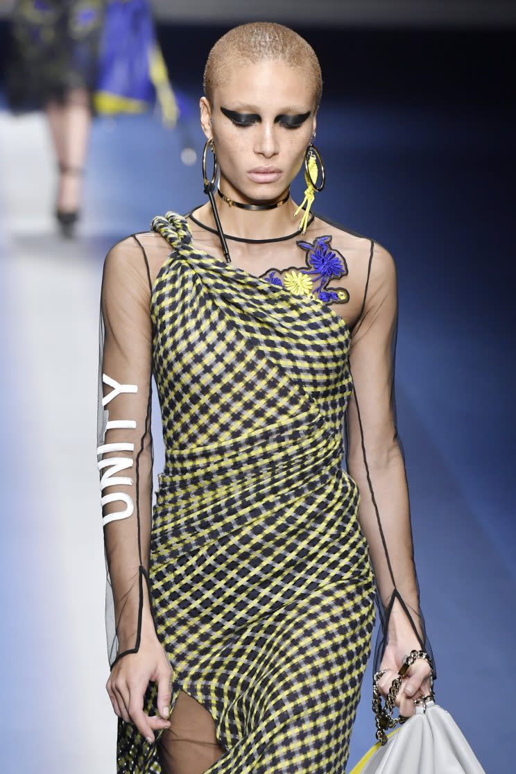 Model Adwoa Aboah walks the Versace runway in heavy black eyeliner, with “Unity” on her sleeve. (Photo: Getty Images)