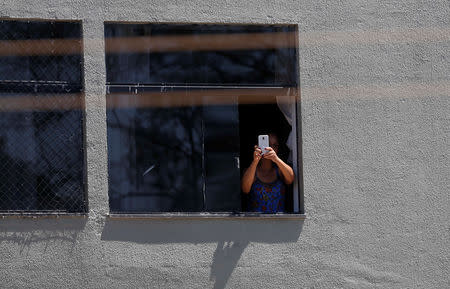 A woman takes a picture of Presidential candidate Jair Bolsonaro's rally in Taguatinga near Brasilia, Brazil September 5, 2018. REUTERS/Adriano Machado