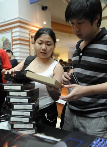 Fans collect newly released copies of Diablo III, the latest edition from the videogame franchise, during a launch event at a computer mall in Singapore on May 15, 2012. Thousands of people queud outside the mall, many of them taking time off from work or school to grab their copies. (AFP Photo/Simin Wang)