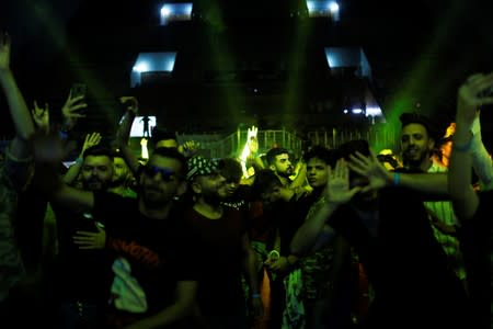 Young people dance and cheer as they attend electronic music concert with western tunes at closed Hall in Shaab Stadium for the first time in Baghdad