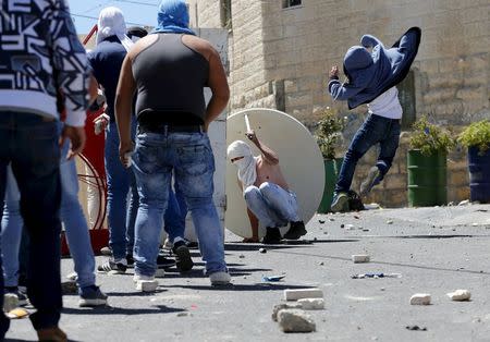 Palestinian youths throw stones towards Israeli police during clashes in the East Jerusalem neighbourhood of A-tur, after a Palestinian youth was killed by Israeli security forces April 25, 2015. REUTERS/Ammar Awad