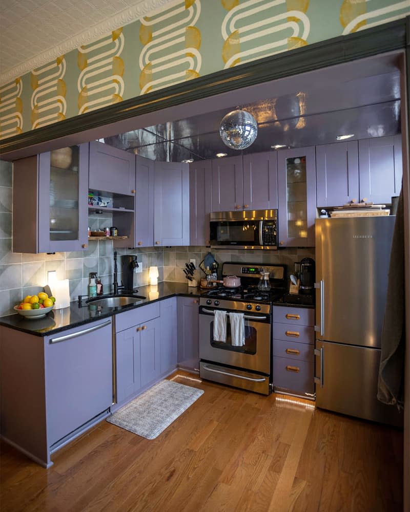 Purple cabinets in renovated kitchen with disco ball on ceiling