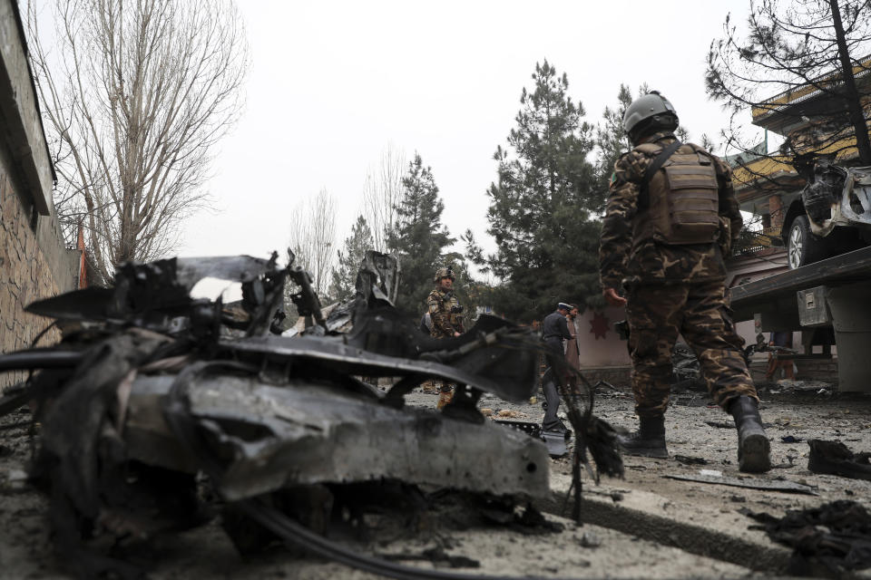 Security personnel inspect the site of a bomb attack in Kabul, Afghanistan, Saturday, Feb. 20, 2021. Three separate explosions in the capital Kabul on Saturday killed and wounded numerous people an Afghan official said. (AP Photo/Rahmat Gul)