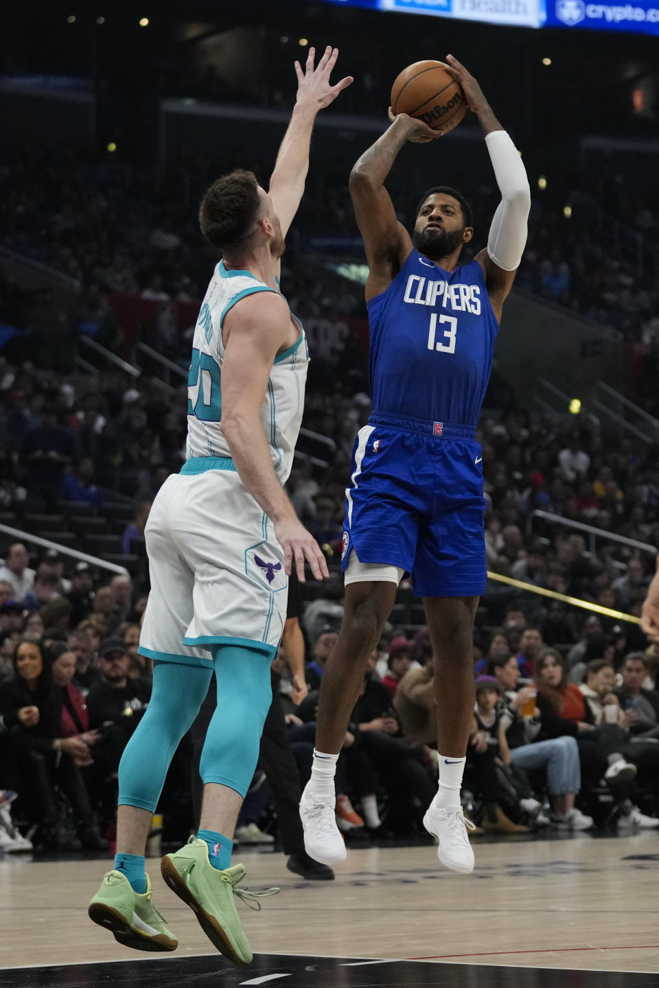 Los Angeles Clippers forward Paul George (13) shoots against Charlotte Hornets forward Gordon Hayward (20) during the first half of an NBA basketball game in Los Angeles, Tuesday, Dec. 26, 2023. (AP Photo/Ashley Landis)