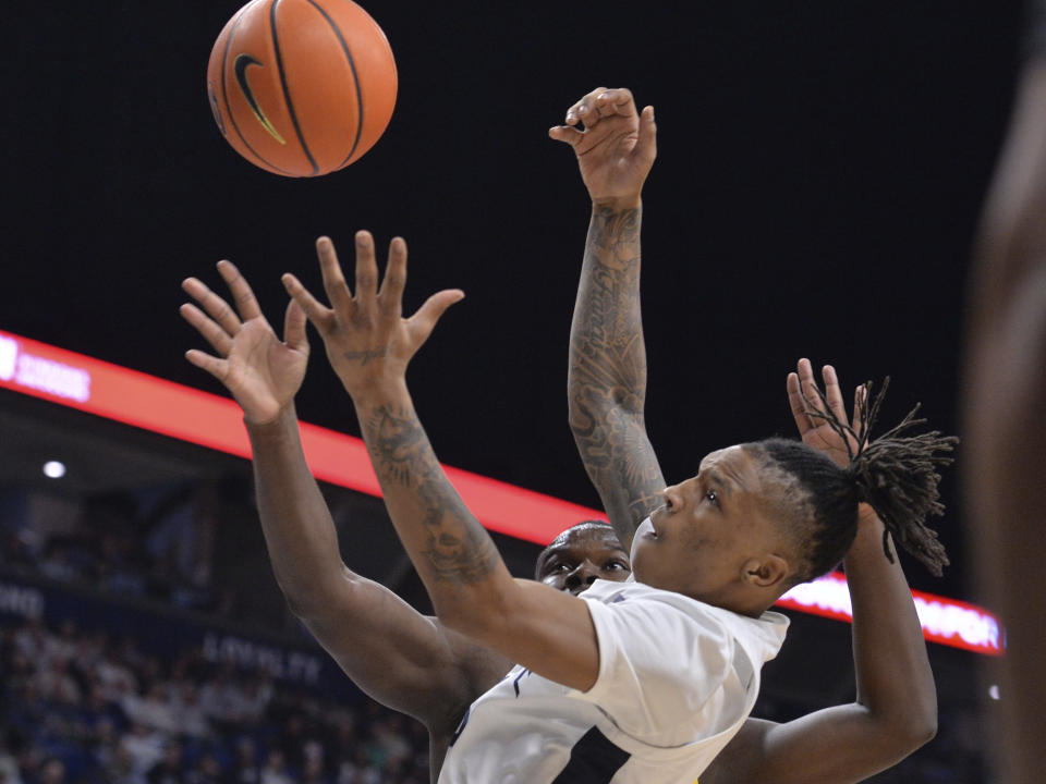 Penn State's Nick Kern Jr., foreground, drives to the basket against Iowa's Ladji Dembele during the first half of an NCAA college basketball game Thursday, Feb. 8, 2024, in State College, Pa. (AP Photo/Gary M. Baranec)