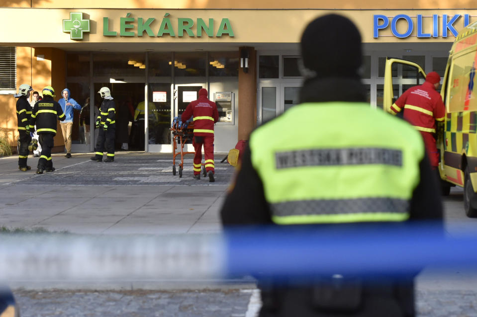 Firefighters, police officers and paramedics in front of the Ostrava Teaching Hospital, after a shooting incident in Ostava, Czech Republic, Tuesday, Dec. 10, 2019. Police and officials say at least four people have been killed in a shooting in a hospital in the eastern Czech Republic. Two others are seriously injured. (Jaroslav Ozana/CTK via AP)