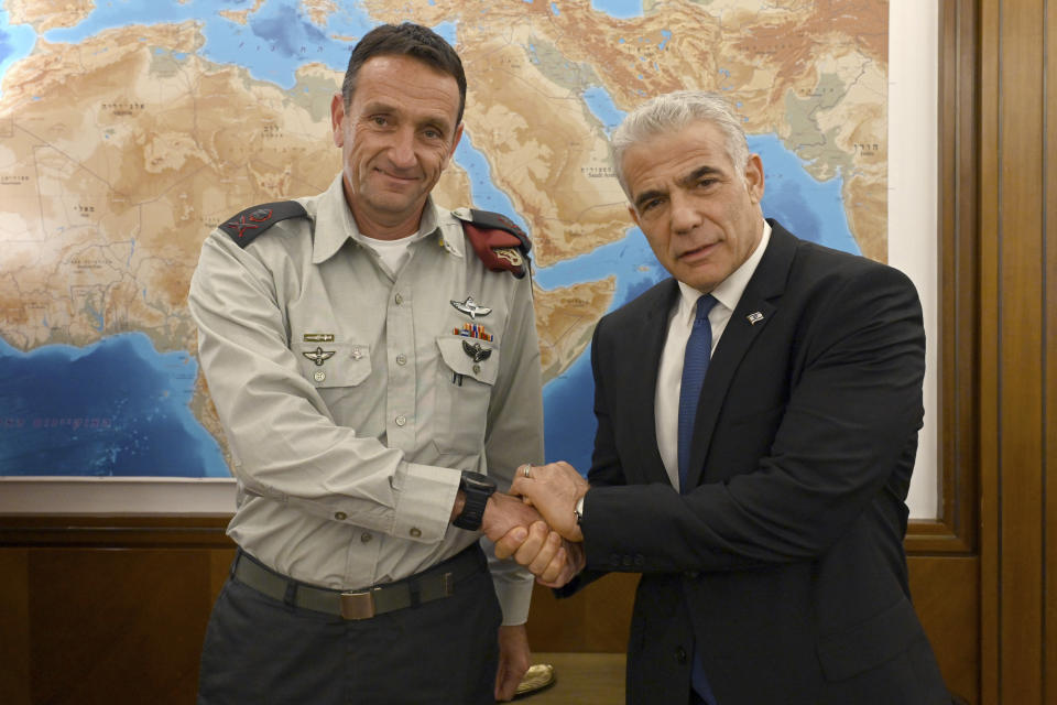 In this photo provided by the Government Press Office, Israeli Prime Minister Yair Lapid, right, poses for a photo with Israel's next military chief Maj. Gen. Herzi Halevi in Jerusalem, Aug. 3, 2022. For the first time, a Jewish West Bank settler is set to take the reigns as chief of staff of Israel's military, the enforcer of the country's 55-year-old military occupation. Halevi’s rise caps the decades-long transformation of the settler movement from a small group of religious ideologues to a diverse and influential force at the heart of the Israeli mainstream. (Haim Zach/Israeli Government Press Office via AP)