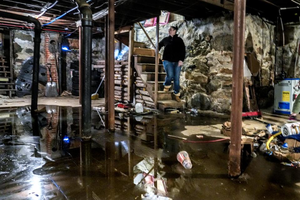 Melissa Grussi looks at the puddle on her basement floor caused by a leak in the kitchen sink.