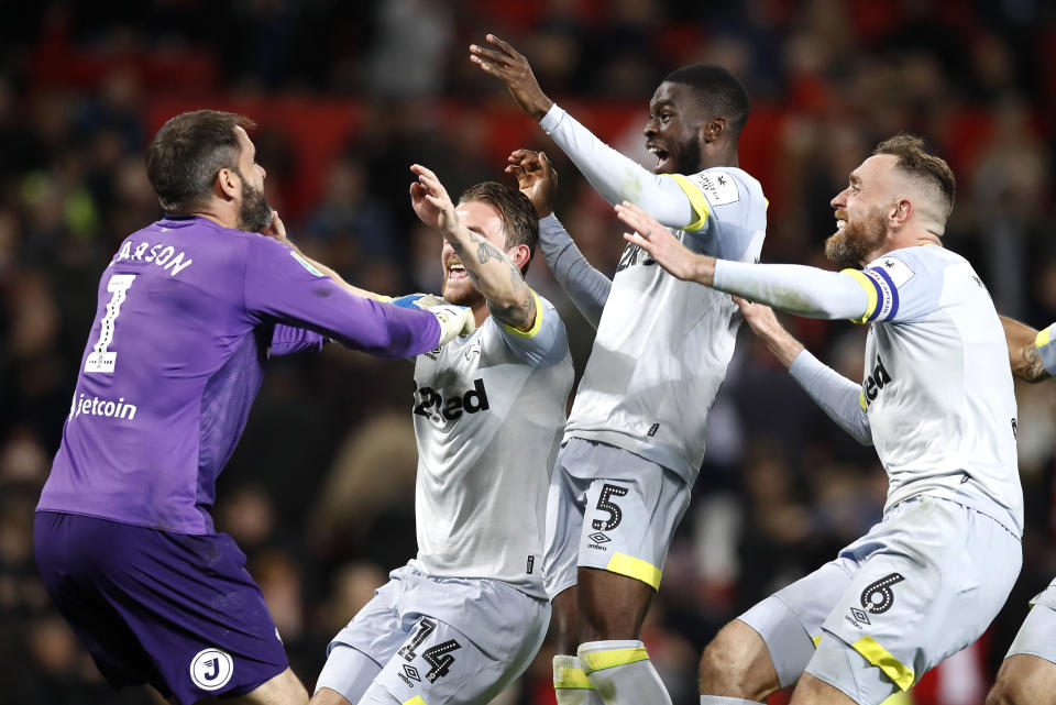 Derby County goalkeeper Scott Carson, left, celebrates winning the penalty shootout with team mates during the match against Manchester United during the English League Cup, third round soccer match at Old Trafford in Manchester, England, Tuesday Sept. 25, 2018. (Martin Rickett/PA via AP)