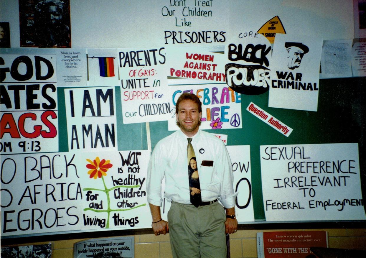 Rodney Wilson stands among a collection of hand-drawn protest signs created by his students at the Mehlville R-IX School District in St. Louis. Wilson was a high school science teacher at the district from 1990-1997. He founded LGBT History Month in 1994.