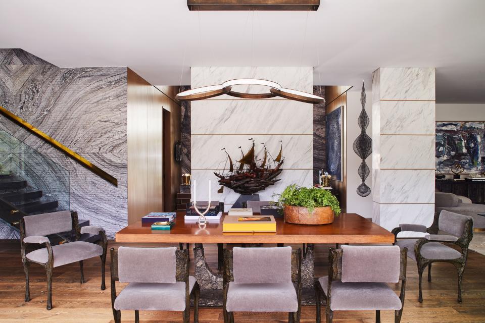 The dining room is situated in the heart of the house, where it is dressed with a Christopher Boots–designed chandelier and Paul Evans–designed furniture (including the chairs and table). The walls are covered with some of the 160 slabs of Italian marble that Soare ordered for the interiors. “The marble is hammered so that it has the look of stone,” she says. “Nothing is too, too finished—nothing is shiny.”
