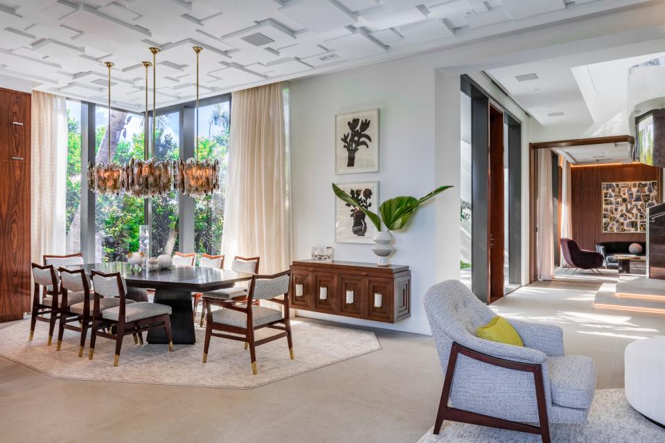 A pair of 1960s Mazzega Murano pendants illuminate a table designed by Brown Davis for Keith Fritz Fine Furniture in a Miami Beach dining area.