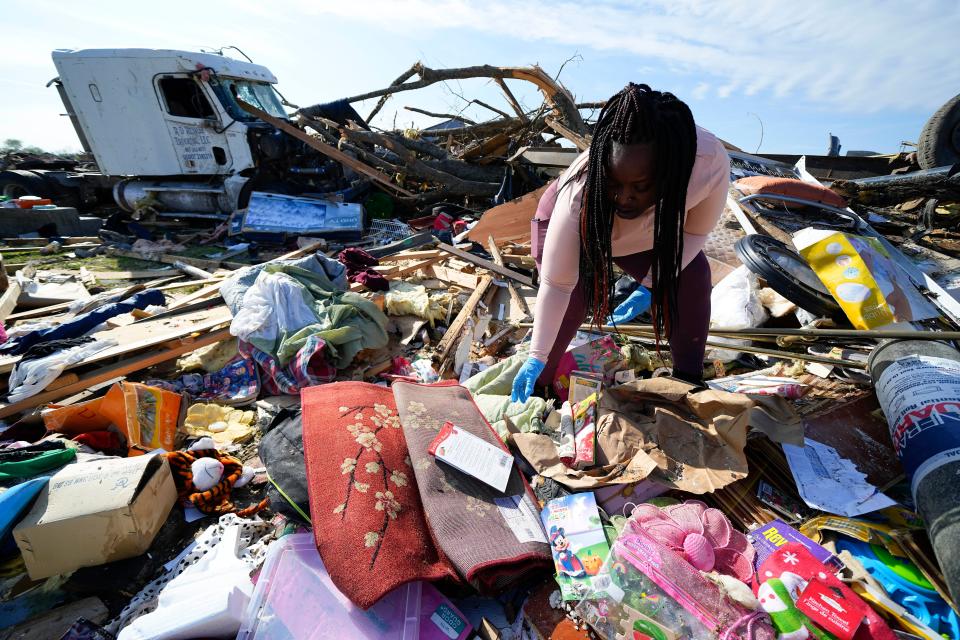 Kimberly Patton surveys through the belongings at the spot of a family member's home after a tornado destroyed the property March 26, 2023, in Rolling Fork, Miss. A new study says warming will fuel more supercells or tornados in the United States and that those storms will move eastward from their current range.
