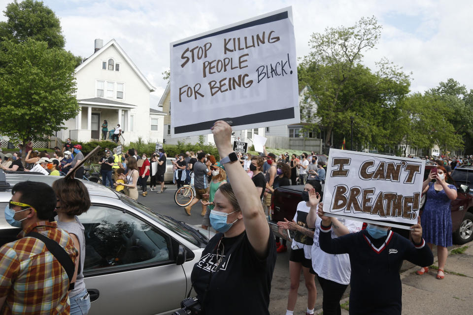 "Dejen de matar gente por ser negra" y "¡No puedo respirar!" dicen algunos de los carteles que llevaban manifestantes durante una protesta por la muerte de George Floyd el 26 de mayo del 2020 en Minneapolis. Floyd, quien era negro, falleció el 25 de mayo cuando un policía blanco lo inmovilizó apoyando su rodilla en su cuello tras detenerlo por error. (AP Photo/Jim Mone)