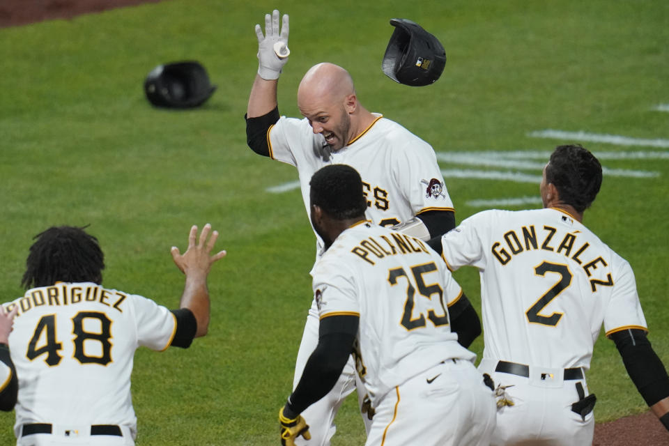 Pittsburgh Pirates' Jacob Stallings, rear, throws off his helmet as he approaches home plate after hitting a solo, walk-off home run off Chicago Cubs relief pitcher Andrew Chafin during the bottom of the ninth inning of a baseball game in Pittsburgh, Tuesday, Sept. 22, 2020. The Pirates won 3-2. (AP Photo/Gene J. Puskar)