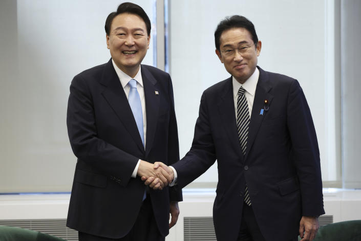 FILE - South Korean President Yoon Suk Yeol, left, shakes hands with Japanese Prime Minister Fumio Kishida before their meeting in New York on Sept. 21, 2022. South Korea’s president wants Japan to join his efforts to improve ties frayed over Tokyo’s past colonial rule, saying there is an increasing need for greater bilateral cooperation because of North Korean nuclear threats and global supply chain challenges. (Ahn Jung-won/Yonhap via AP, File)