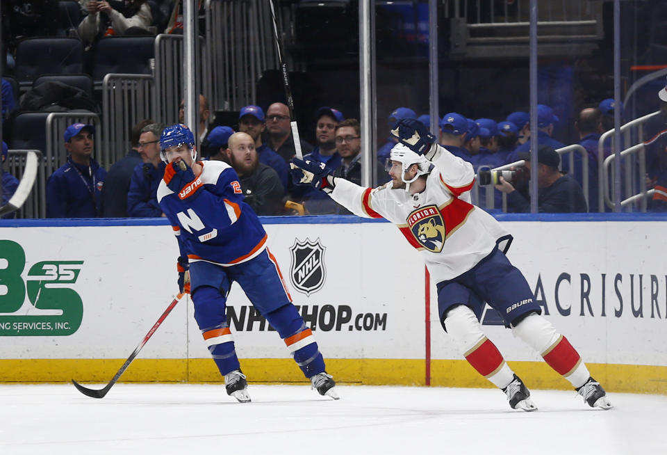 Florida Panthers defenseman Oliver Ekman-Larsson, right, celebrates his overtime goal, next to New York Islanders defenseman Mike Reilly (2) during an NHL hockey game Saturday, Jan. 27, 2024, in Elmont, N.Y. The Panthers won 3-2. (AP Photo/John Munson)