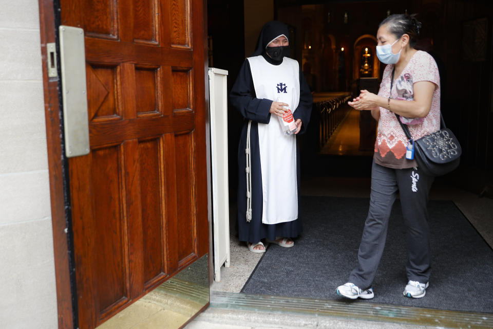 Una parroquiana se desinfecta las manos tras asistir a una misa en español en la iglesia San Bartolomeo de Queens, Nueva York, el 6 de julio del 2020. (AP Photo/John Minchillo)