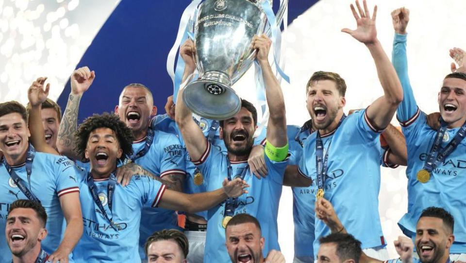 Manchester City players lift the Champions League trophy