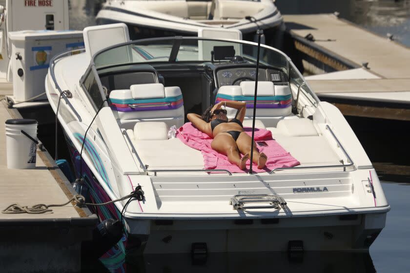 Los Angeles, California-Sept 5, 2022-Blanca Herrera, of Compton, CA, sunbaths on a boat in San Pedro, CA on Sept. 5, 2022. As the temperature remains high on Labor Day 2022, people had to the waterfront for relief, Sept. 5, 2022. (Carolyn Cole / Los Angeles Times)