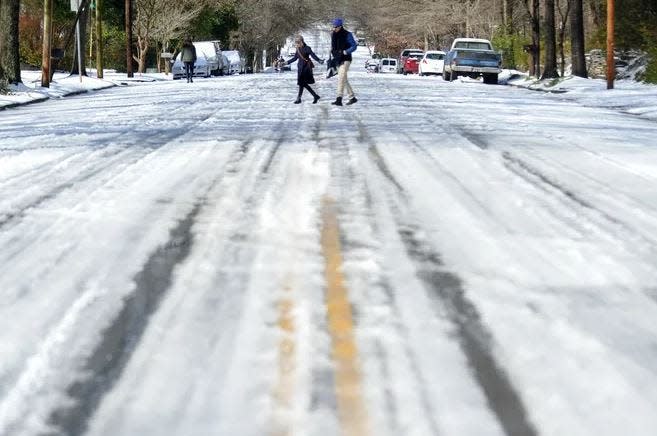 People cross a road during a snowstorm in Athens that occurred in February 2014.