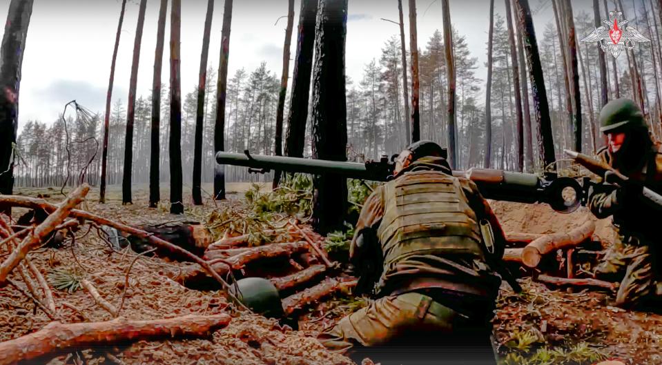 In this handout photo taken from a video released by Russian Defense Ministry Press Service on Monday, March 27, 2023, Russian paratroopers aim a weapon fire toward Ukrainian position at an undisclosed location.