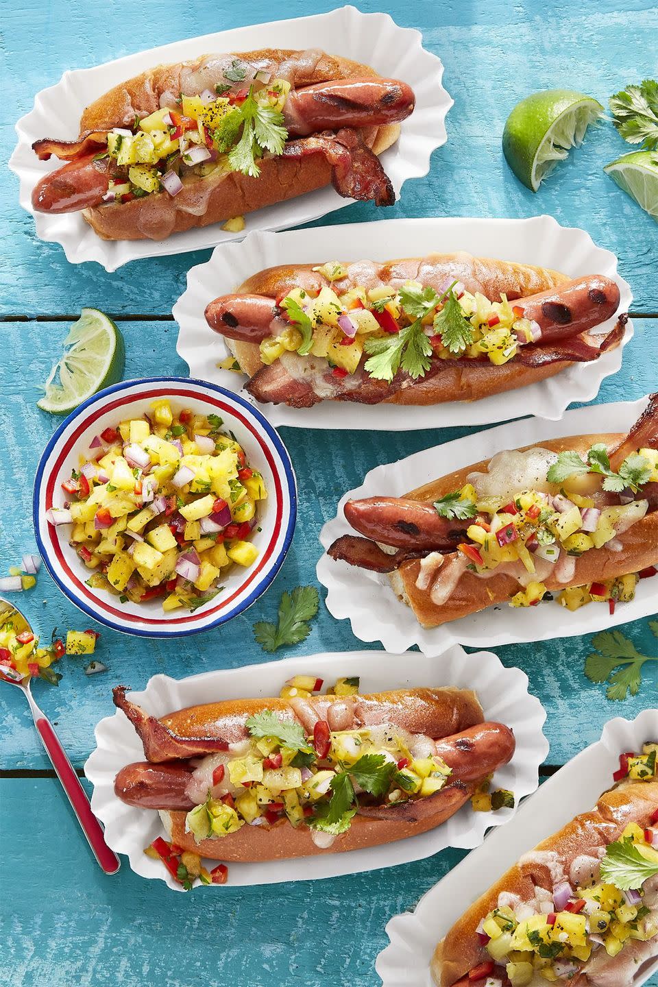 hatch pineapple salsa in a bowl with some hot dogs next to it with the salsa on top
