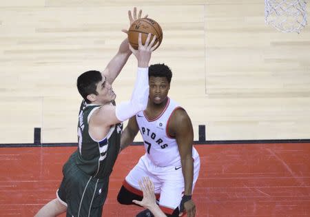 May 21, 2019; Toronto, Ontario, CAN; Milwaukee Bucks forward Ersan Ilyasova (77) shoots the ball past Toronto Raptors guard Kyle Lowry (7) during the fourth quarter in game four of the Eastern conference finals of the 2019 NBA Playoffs at Scotiabank Arena. Mandatory Credit: Nick Turchiaro-USA TODAY Sports