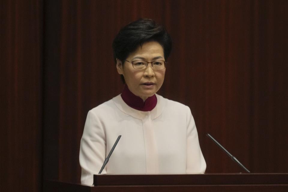 Hong Kong Chief Executive Carrie Lam, center, attends her policy address at the chamber of Legislative Council in Hong Kong, Wednesday, Oct. 6, 2021. Lam announced a major development plan Wednesday for Hong Kong's border area with mainland China in the last annual policy address of her current term. (AP Photo/Kin Cheung)