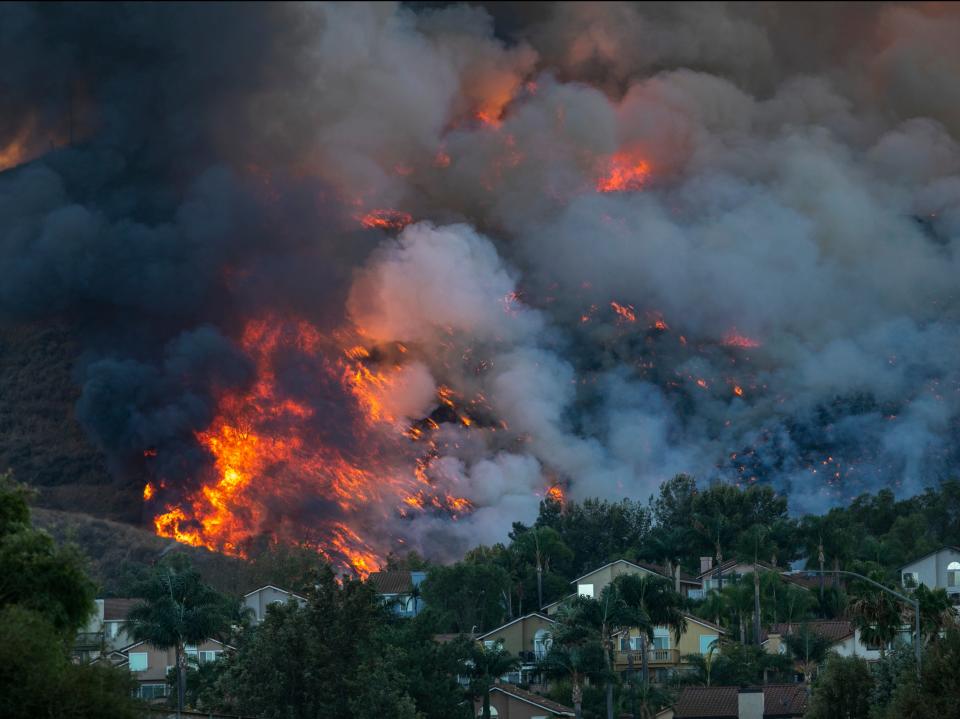 <p>Flames rise near homes during the Blue Ridge Fire on 27 October in Chino Hills, California</p>Getty