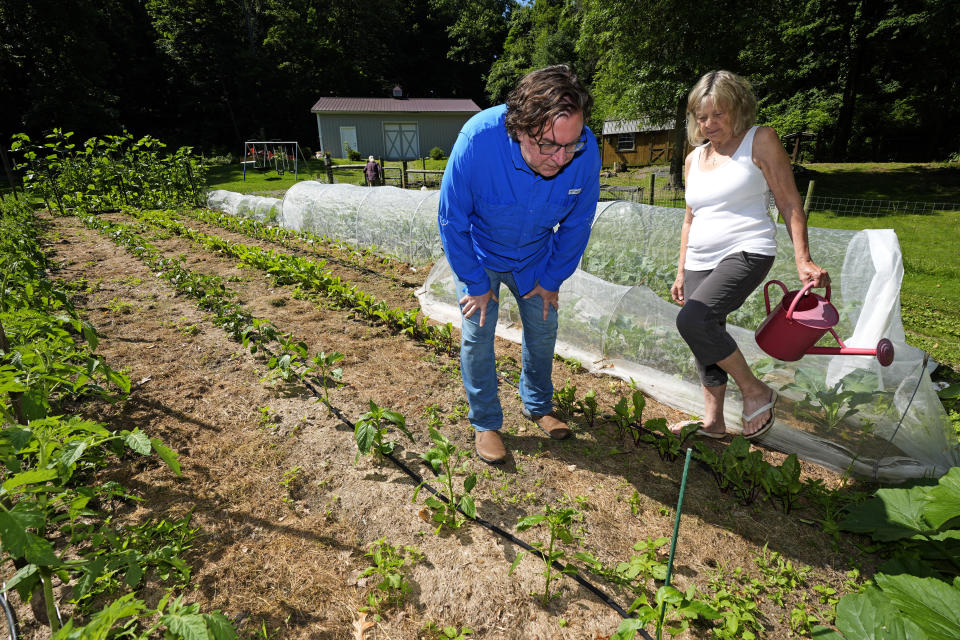 CORRECTS NAME SPELLING TO FIGLEY NOT FINLEY East Palestine, Ohio resident Marilyn Figley, right, talks with Scott Smith, in her garden on Wednesday, June 12, 2024. Figley planted a garden in 2024 after the derailment of a Norfolk Southern train near her home, using one of her husband's tractors to remove the top three inches of soil and replace with fresh dirt. (AP Photo/Gene J. Puskar)