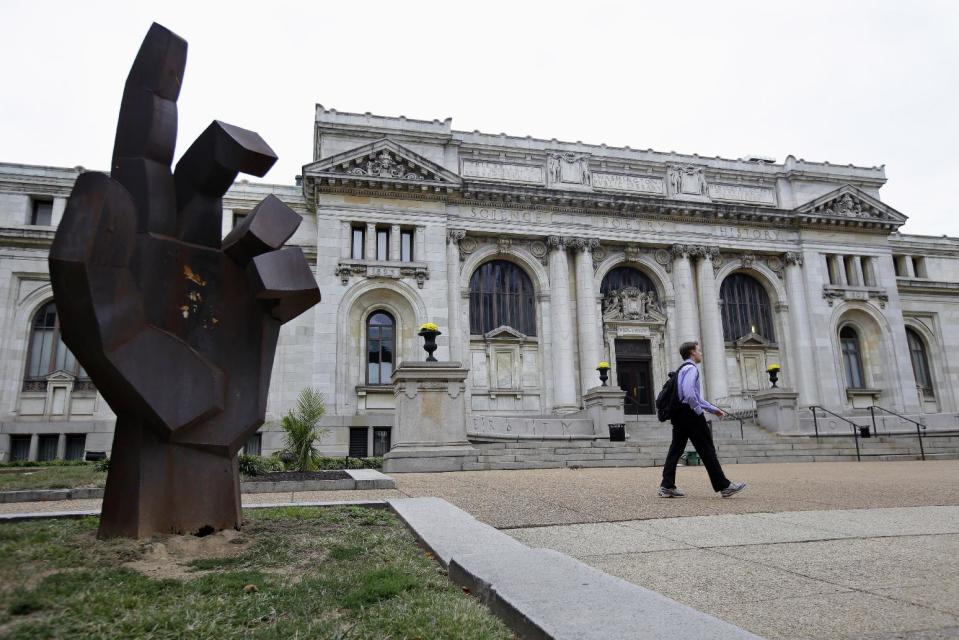 A man walks past the historic Carnegie Library building in Washington, Monday, Sept. 23, 2013. The International Spy Museum, one of the hottest attractions in the nation’s capital over the past decade, is considering a move to a historic library that would give it more space for exhibits and a link to the city’s convention center. (AP Photo/Jacquelyn Martin)