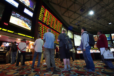FILE PHOTO: People wait in line to place bets after Super Bowl XLVIII proposition bets were posted at the Las Vegas Hotel & Casino Superbook in Las Vegas, Nevada, U.S., January 23, 2014. REUTERS/Las Vegas Sun/Steve Marcus/File Photo