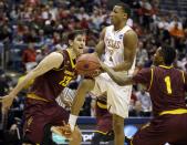 Texas' Demarcus Holland (2) is fouled by Arizona State's Jahii Carson (1) as Arizona State's Jordan Bachynski (13) watches during the first half of a second-round game in the NCAA college basketball tournament Thursday, March 20, 2014, in Milwaukee. (AP Photo/Jeffrey Phelps)