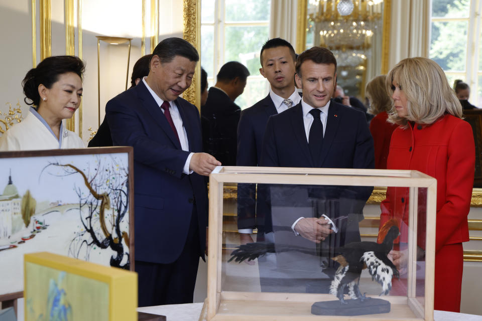 China's President Xi Jinping, second left, presents gifts to French President Emmanuel Macron, while China's First Lady Peng Liyuan, left, Brigitte Macron, right, look on during the nations gifts exchange at the Elysee Palace in Paris, Monday, May 6, 2024. China's President Xi Jinping is in France for a two-day state visit that is expected to focus both on trade disputes and diplomatic efforts to convince Beijing to use its influence to move Russia toward ending the war in Ukraine. (Ludovic Marin, Pool via AP)