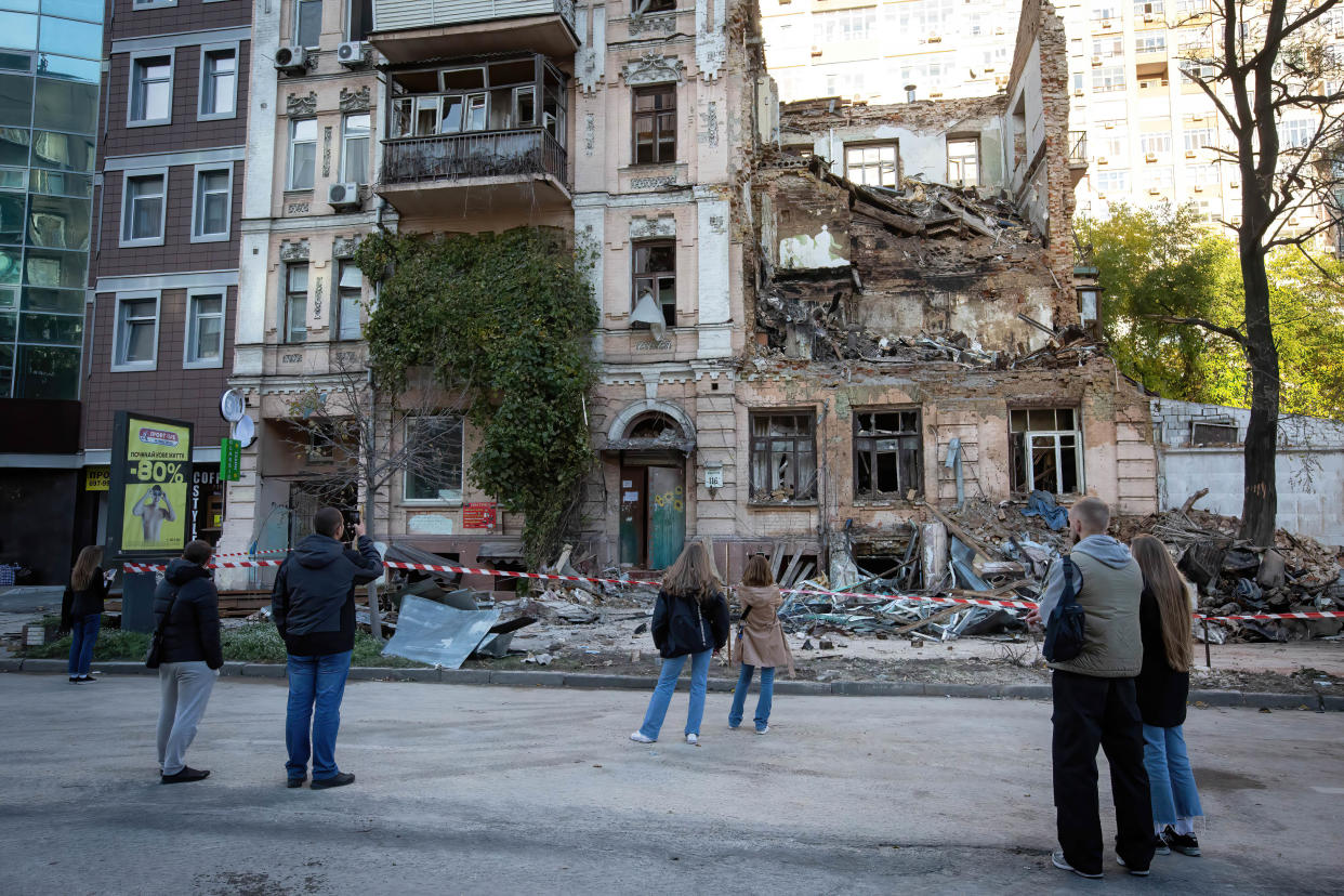 People look at the residential building destroyed by a Russian drone strike, which local authorities consider to be Iranian-made unmanned aerial vehicles (UAVs) Shahed-136, in central Kyiv. (Oleksii Chumachenko/SOPA Images/LightRocket via Getty Images)